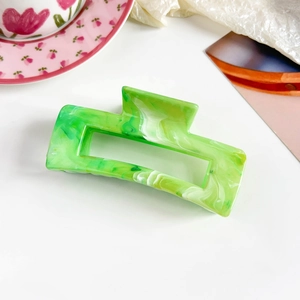 Detail of green marble rectangle hair claw clip on a stylish artistic background