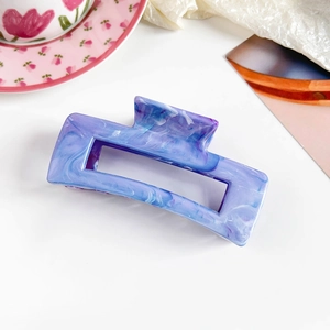 Detail of purple marble rectangle hair claw clip with acetate finish on white background