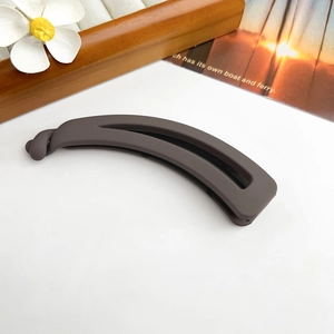 Détail de la pince à cheveux banane marron mat avec structure creuse et fermoir