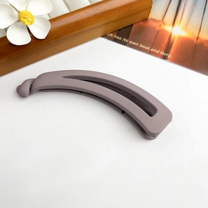 Détail d'une pince à cheveux banane évidée violette mate sur un décor esthétique