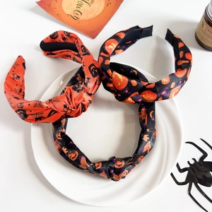 Detail view of Halloween knot headbands with pumpkin and spider web fabric patterns