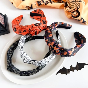 Detailed view of four knotted Halloween headbands with pumpkin and ghost patterns