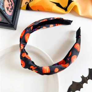 Detail of Halloween knot headband featuring orange pumpkin and purple witch hat patterns