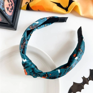Detail of Halloween knot headband featuring spooky pumpkin, bat, and spider web patterns