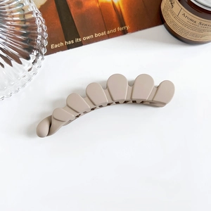 Vue détaillée d'une pince banane mate kaki avec un design ajouré pour les cheveux