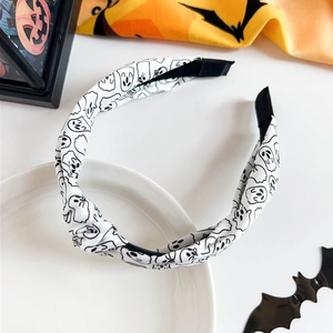 Macro shot of Halloween ghost print headband with knot detail on white fabric background