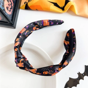 Detail of Halloween knotted headband with pumpkin, bat and spider web patterns