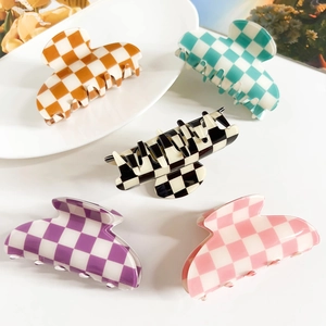Flat lay of five colorful checkerboard pattern hair clips in various trendy shades
