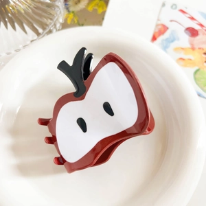 Close-up of red apple-shaped PVC hair claw clip with detailed white sliced fruit design