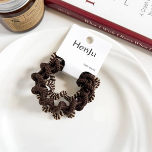 Close-up of high-elastic spiral hair bands in coffee tones on a white ceramic plate