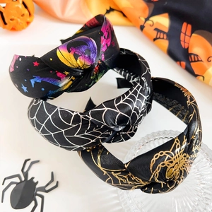 Détail de serre-têtes d'Halloween noués avec motifs de toiles d'araignées et de crânes