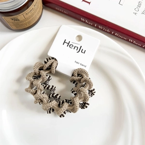 Close-up of knitted hair ties with wave and striped patterns on a display tray