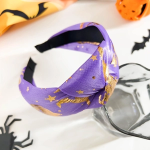 Détail du serre-tête torsadé en satin violet avec motifs étoiles et lunes dorées