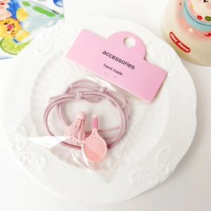 Detail showing pink badminton racket and birdie charms on an elastic hair tie