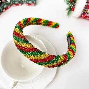 Detail of handmade Christmas headband with red green and gold glitter spiral stripes