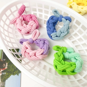 Detail of colorful chunky braided hair ties in a white basket showing texture