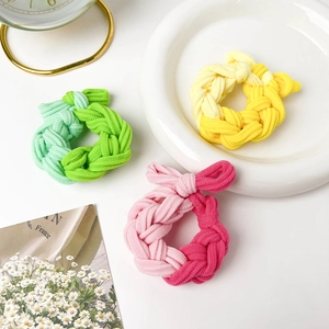 Detailed view of woven twisted hair ties in pastel pink, yellow, and green sets