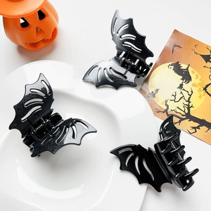 Close-up of black bat hair claws on white plate for Halloween accessory styling