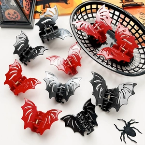 Group of red and black bat claw clips with Halloween pumpkin decor on white background