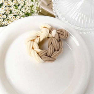 Detailed macro view of the cream and light coffee braided texture on this elastic hair tie