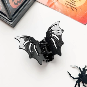 Macro shot of matte black bat hair claw clip with cutout wing design for Halloween