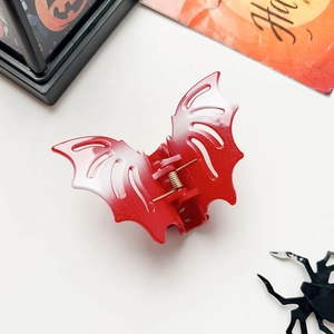 Detail of red bat hair claw with glitter finish and white gradient for Halloween