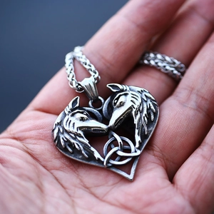 Viking wolf heart pendant with celtic knot on twisted chain held in hand