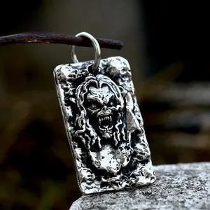 Macro detail of gothic skull relief on vintage stainless steel rectangular pendant