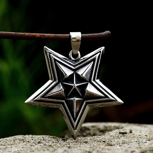 Vintage stainless steel pentagram pendant on rusty wire over a natural rock base