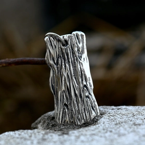 Macro shot of vintage silver skull pendant showing textured wood grain metal craftsmanship