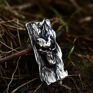 Detail of vintage gothic skull pendant with tree bark texture on weathered steel