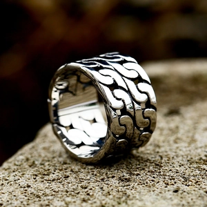 Men's vintage stainless steel Cuban link ring with oxidized finish on natural rock