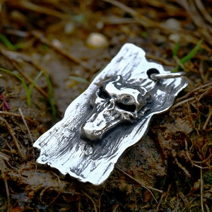 Detailed view of vintage gothic skull pendant with wood grain texture and antique silver finish