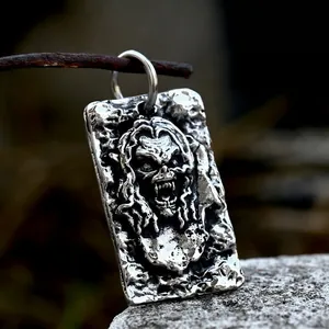 Vintage stainless steel skull pendant with gothic relief on a rusty wire backdrop