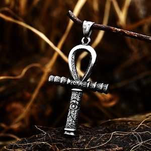 Vintage stainless steel Ankh cross pendant with Eye of Horus on rustic wood branch