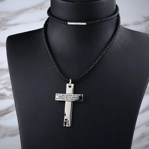 Stainless steel cross skull necklace with black leather cord on a display stand
