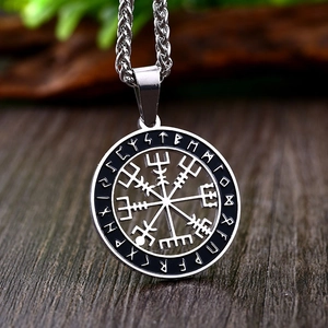 Macro shot of silver viking vegvisir compass pendant with black rune symbols on steel