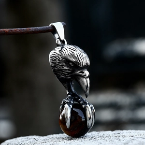 Detailed view of eagle claw pendant holding a tiger eye stone in vintage steel