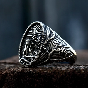 Vintage stainless steel nautical lighthouse ring for men on dark rock background