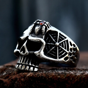 Anillo gótico de calavera en acero inoxidable con circón rojo y diseño de telaraña