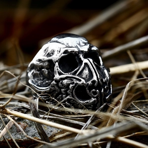 Men's punk gothic skull ring in vintage stainless steel on a rustic stone background