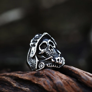 Vintage gothic skull ring in stainless steel with antique silver finish on wood base