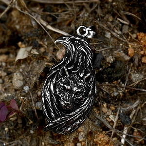 Detailed view of vintage steel eagle and wolf head pendant with intricate feather texture