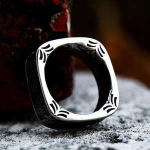 Detailed macro shot of vintage stainless steel ring with square engraved feather patterns