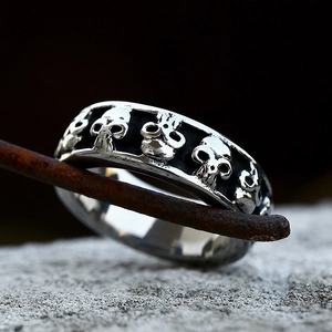 Gothic punk skull ring in stainless steel with 3D embossed skulls on a vintage band