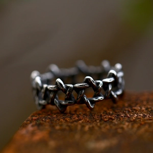 Macro shot of retro stainless steel ring with hexagonal stars and oxidized finish