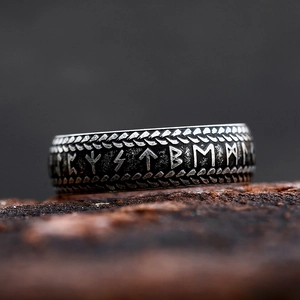 Vintage Viking Rune stainless steel ring with rustic finish on textured rock background