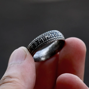 Macro detail of Nordic Viking runes and wheat patterns on a vintage steel ring
