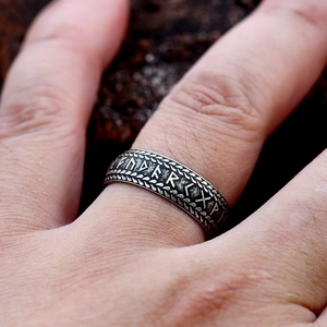 Macro shot of Viking runes engraved on a vintage titanium steel ring for men