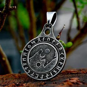 Primer plano de un colgante de lobo vikingo con runas nórdicas en plata antigua